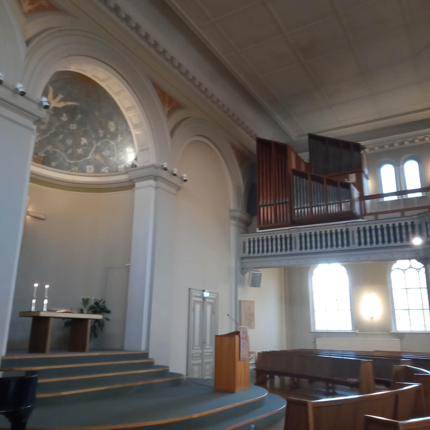 En estrad med en predikstol och orgeln är synlig