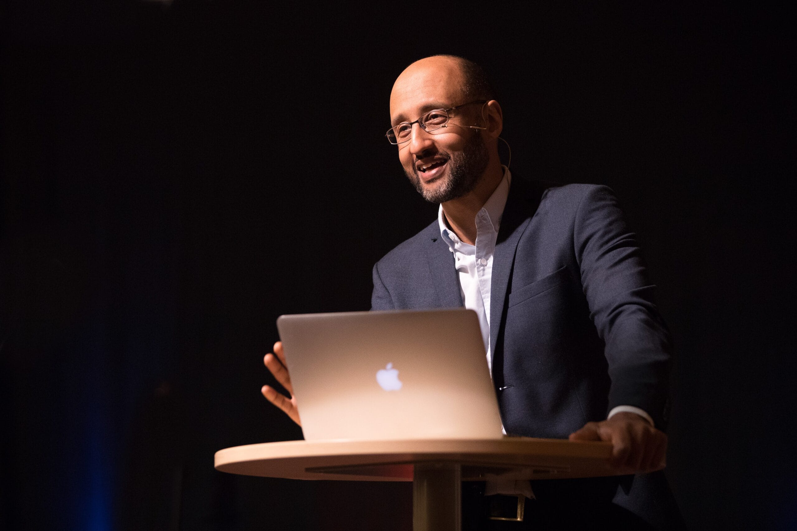 mörkhyad man i en talarstol